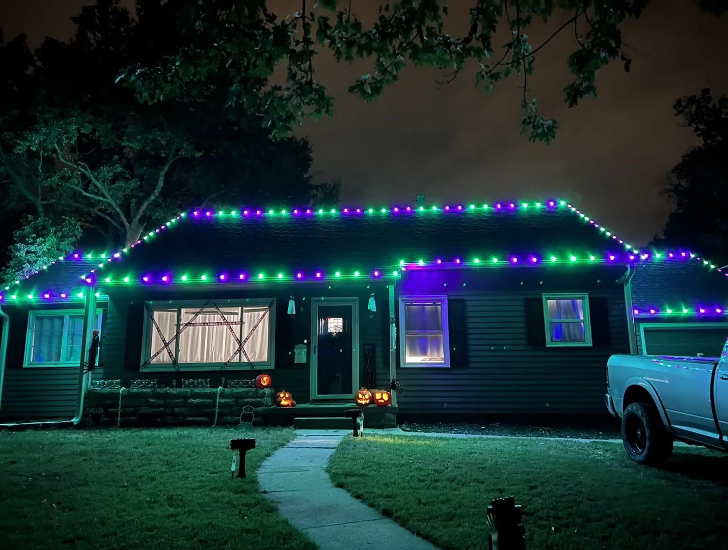 Colorful professional holiday lighting installed along a home's roofline